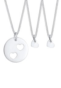 Silberne Halsketten mit einem runden Anhänger, der zwei Herz-Ausschnitte und zwei kleinere Herz-Anhänger enthält. Glatte, polierte Oberfläche, minimalistisches Design.