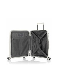 Weißer Hartschalen-Handgepäckkoffer mit offenem Deckel, der das leere Hauptfach mit Kreuzgurt und einem Reißverschluss-Netzfach im Deckel zeigt.