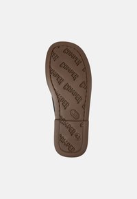 Suela de zapato de goma marrón con el logo "CAMPER" en relieve, una textura lisa, bordes redondeados y un diseño plano adecuado para el uso casual.
