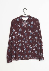 Pitkähihaine blusa tumman viininpunaisesta kankaasta, jossa on sinisiä ja valkoisia kukkakuoseja. V-kaula-aukko ja napitettu hihansuu.