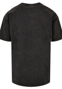 Schwarzes Kurzarm-T-Shirt aus Denim, mit Rundhalsausschnitt, gesticktem Saum und lockerem Schnitt mit subtiler Textur.