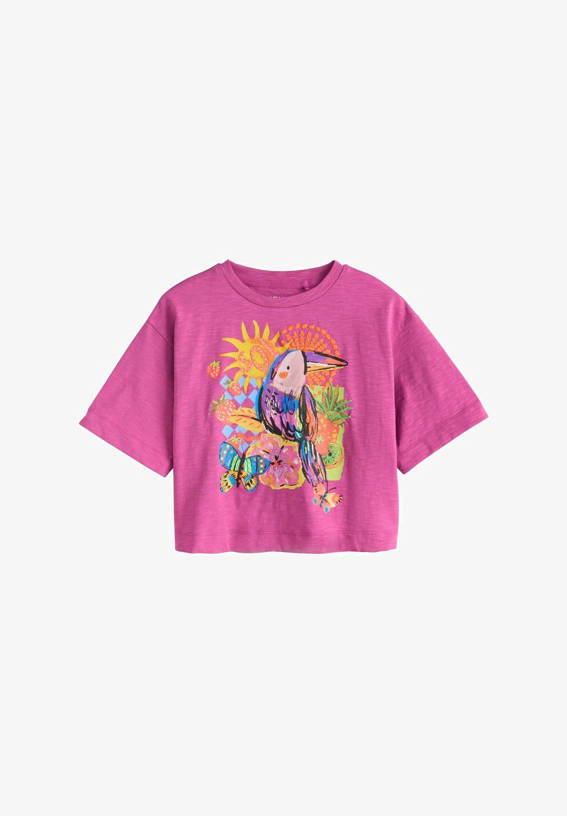 T-shirt à manches courtes rose vif avec un graphisme coloré de toucan, soleil, papillon, fleurs et fruits tropicaux sur le devant.