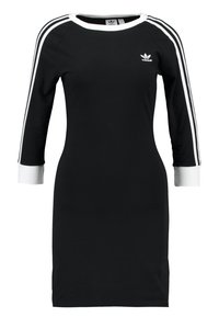 Robe noire avec des manches trois-quarts, des poignets côtelés blancs et trois rayures blanches le long des manches. Présente un petit logo blanc sur la poitrine.