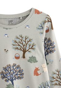 Lys grå babytrøje med illustrationer af frugttræer, svampe, en kurv og små dyr i blå, brune og orange nuancer.