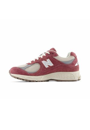 New Balance Sneaker in Bordeaux und Beige mit Mesh- und Wildleder-Obermaterial, weißen Schnürsenkeln und klobiger, strukturierter Sohle, Seitenansicht auf weißem Hintergrund.