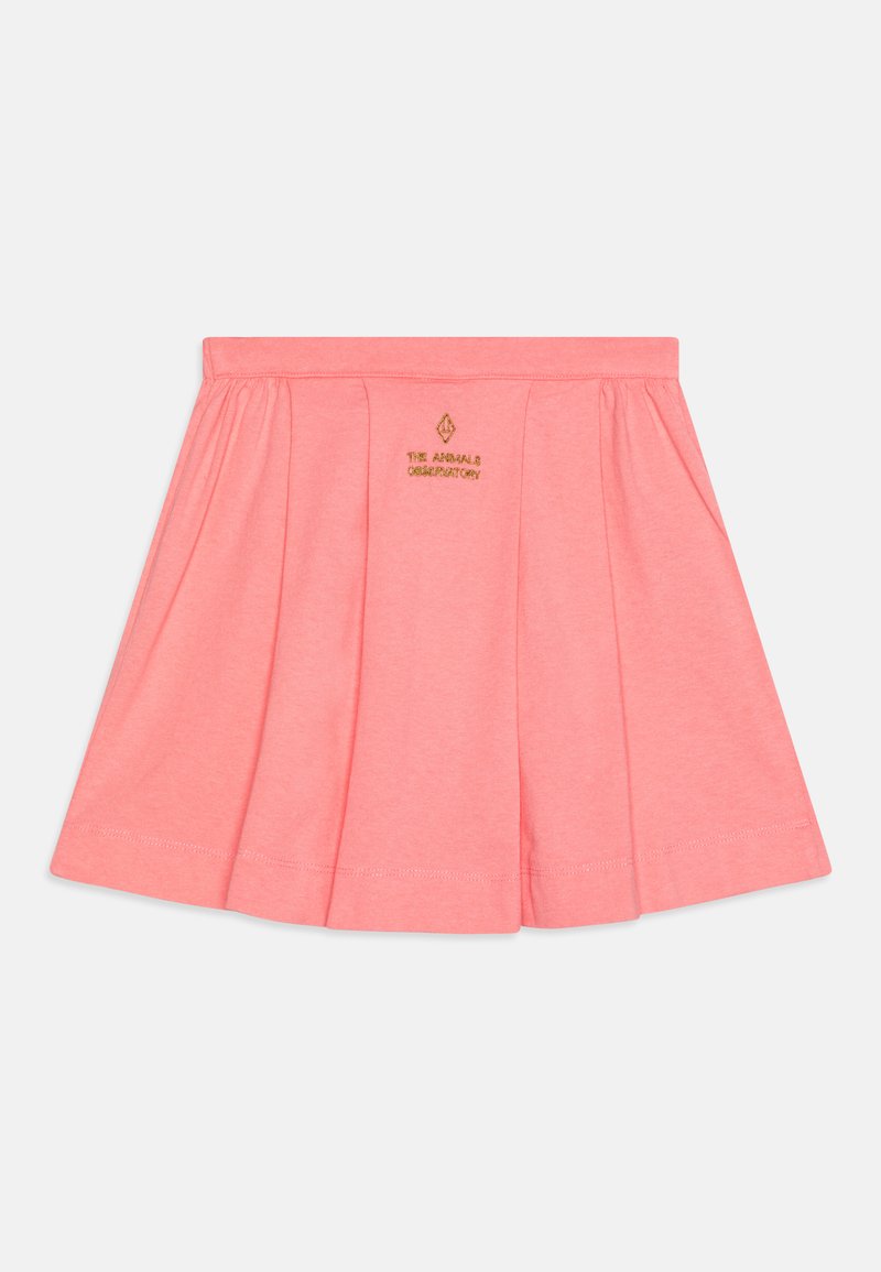 Korallfärgad plisserad kjol i mjuk bomull, med en broderad logotyp i midjan och ett enkelt elastiskt band för komfort.