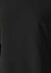 Schwarzes Stoffhemd mit glatter Textur, das ein einfaches Design und eine strukturierte Form aufweist. Keine sichtbaren Muster oder Beschläge.