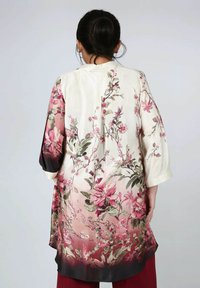 Floral kimono in cream with pink and burgundy gradient. Made of smooth fabric. Features large floral patterns and three-quarter sleeves.