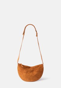 Suede handbag in a warm tan color, featuring a rounded shape and a single adjustable leather strap. Minimalistic design, no visible hardware.