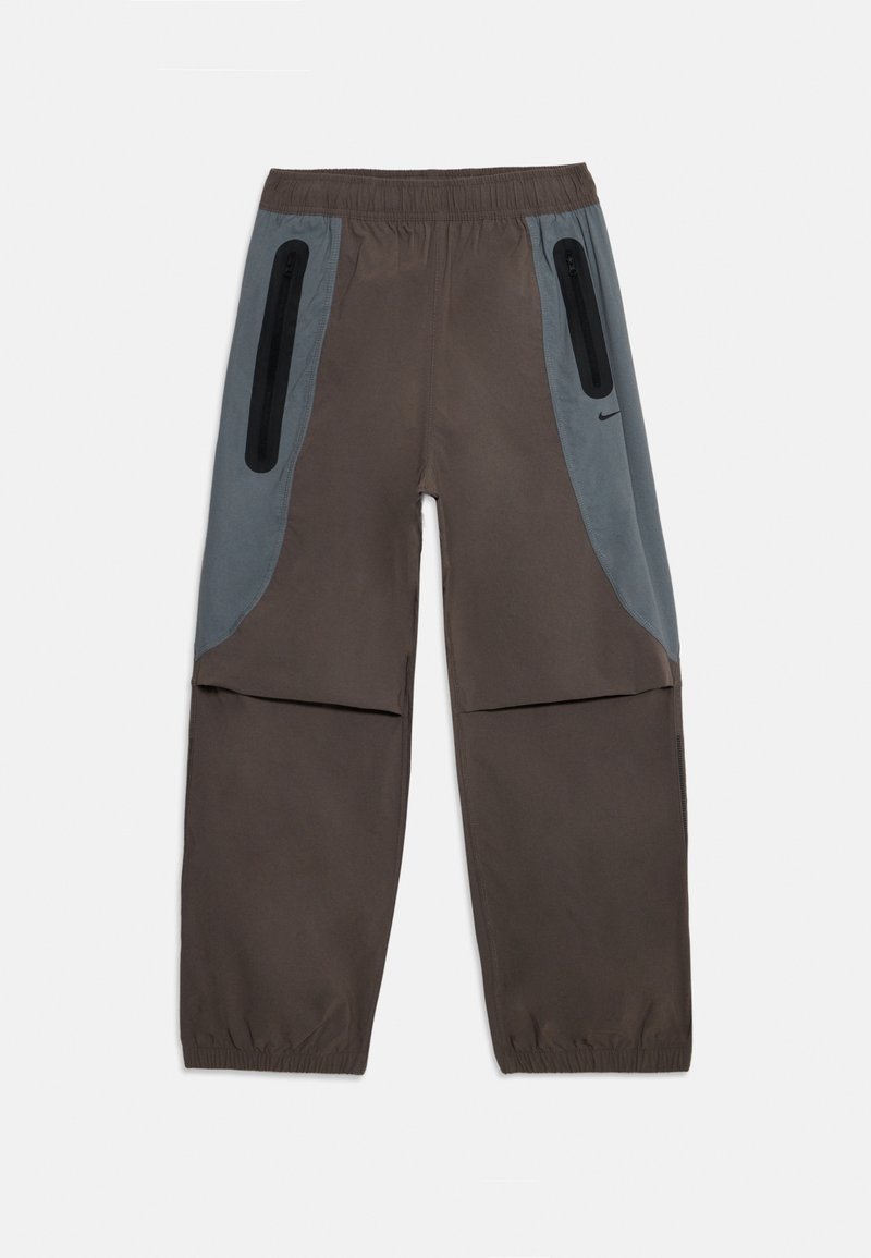 Rjave hlače z sivimi stranskimi paneli, elastičnim pasom in dvema žepoma z zadrgo. Tkanina deluje gladko in lahko.