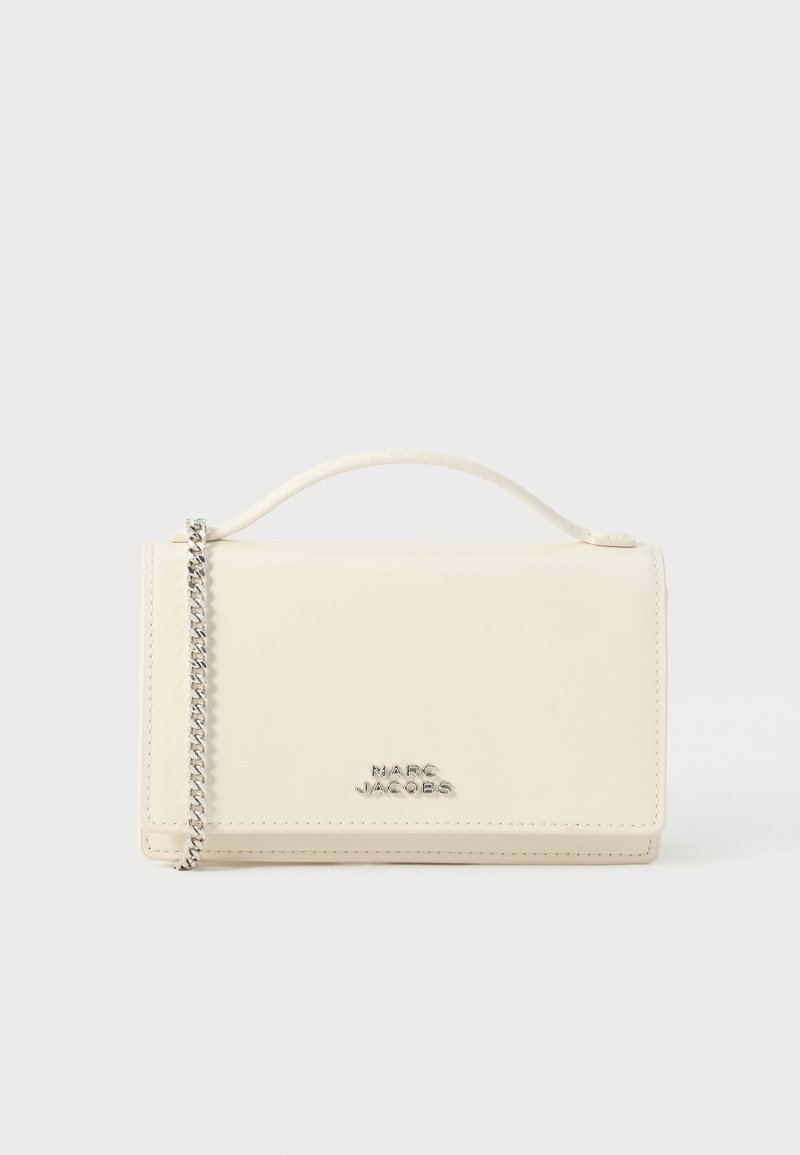 Krydskrops taske i cremefarvet glat læder med sølvkæde som strop og præget logo foran. Rektangulært design.