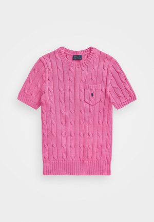 Różowy sweter z krótkim rękawem w warkocze, z okrągłym dekoltem, małą kieszonką na piersi i wyszywanym logo na kieszeni, ułożony na płasko na białym tle.