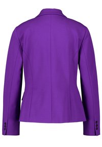 Fialový blazer s přiléhavým střihem, strukturovanými ramenními vypchávkami a peplum spodním lemem. Obsahuje klopu a manžety na knoflíky. Saténová textura.
