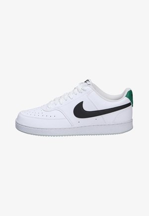 Zapatillas deportivas blancas con parte superior de cuero texturizado, logo Swoosh negro, acentos grises y un tirador verde en el talón. Suela de goma para mejor agarre.