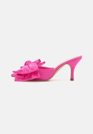 Rosa høyhælte mules med en stor, volangsløyfe foran, glatt stoffoverdel, åpen tå-design og en slank stilettohæl.
