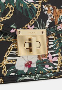 Czarna torebka z żywymi nadrukami tygrysa i kwiatów, złotym okuciem o teksturowanym wykończeniu oraz prostokątnym zapięciem.