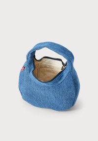 Blauwe denim tas met een ronde vorm, een ritssluiting aan de bovenkant en een enkele handgreep. Het interieur heeft een lichtgekleurde voering.