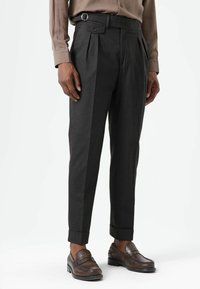 Grijze geplooide broek met een getailleerde taille, sierlus en zijzakken. Stof heeft een gladde textuur, ontworpen voor een slanke pasvorm.