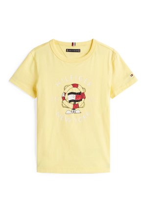 Gelbes T-Shirt mit kurzen Ärmeln und rundem Ausschnitt, mit einer Cartoon-Rettungsring-Figur und dem Schriftzug „Hilfiger New York 1985“ auf der Vorderseite.