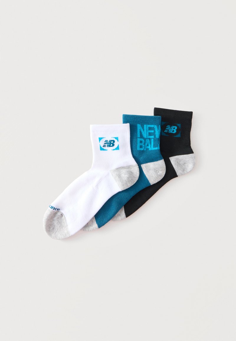 Τρία κάλτσες αστραγάλου New Balance σε λευκό, τυρκουάζ και μαύρο με γκρι φτέρνες και δάκτυλα, τοποθετημένα σε ανεμιστηροειδή διάταξη σε λευκό φόντο.