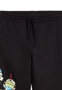 Pantaloni della tuta neri con vita elastica e coulisse, caratterizzati da una grafica colorata di uno scheletro che tiene una bevanda sulla coscia sinistra.