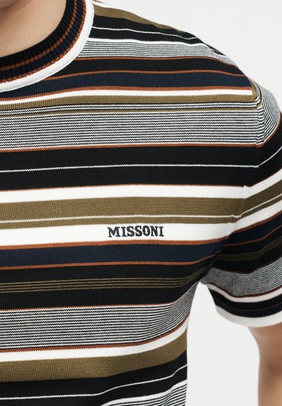 Close-up of a multicolored striped knit shirt with black, white, olive, and rust bands and "MISSONI" embroidered on the chest.
