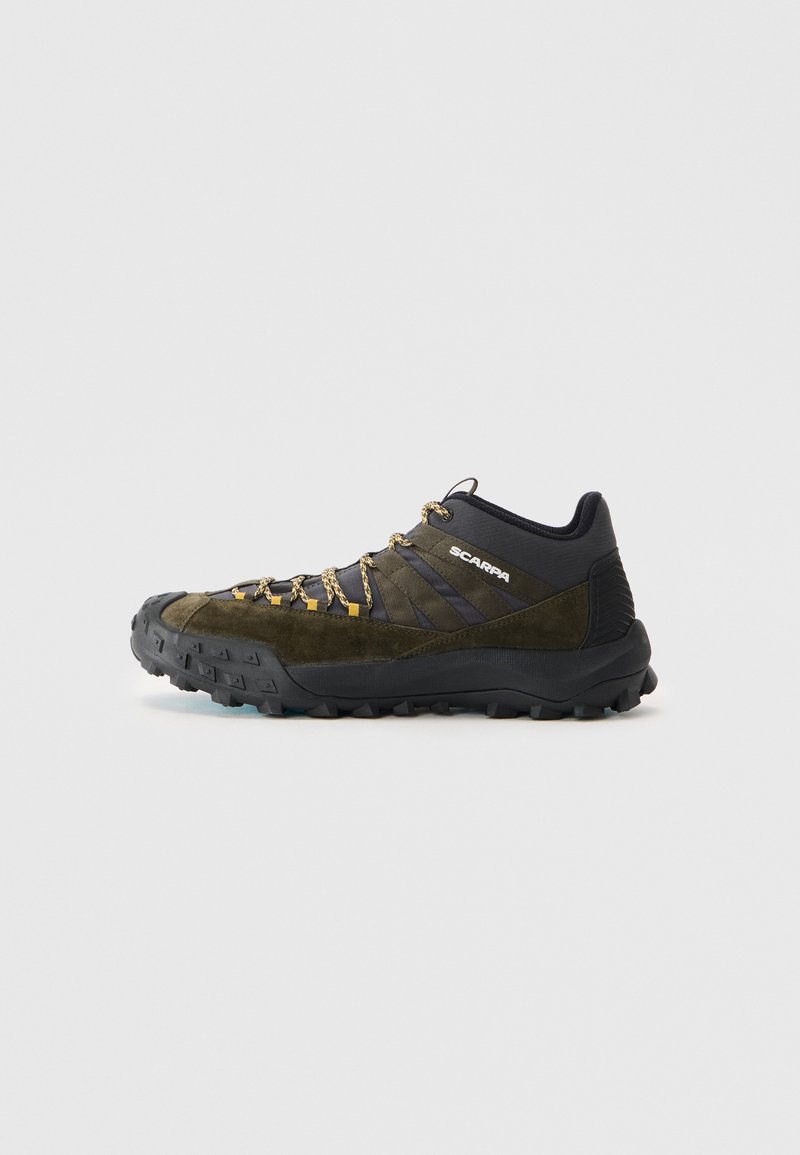Chaussure de randonnée noire et olive avec une tige en daim, une semelle extérieure en caoutchouc texturé, des lacets rehaussés d'or et un capuchon de protection renforcé pour plus de durabilité.
