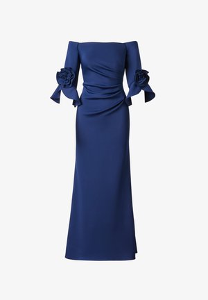 Marineblå aftenkjole med bar skulder, tætsiddende overdel, udvidede albuelange ærmer og store blomsterdekorationer på hvert ærme.