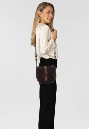 Borsa a tracolla in pelle marrone scuro con perline decorative lungo il centro, forma curva e lunga tracolla regolabile.