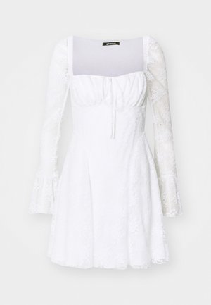 Vestido blanco con un cuerpo ajustado, escote cuadrado y mangas largas de gasa. Puños acampanados, tejido texturado y detalles fruncidos en la parte frontal.