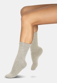 Hellgraue, gerippte Socken aus einem weichen, strukturierten Material. Verfügt über eine bequeme Bündchenpartie und ein glattes Zehendesign.
