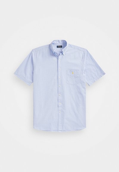 Κοντομάνικο, πουκάμισο με κουμπιά σε ανοιχτό γαλάζιο χρώμα με λευκές ρίγες; διαθέτει τσέπη στο στήθος και κεντημένο λογότυπο. Υλικό από βαμβάκι.