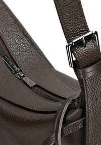 Hnědá taška přes rameno z texturované kůže se zapínáním na zip, kovovými komponenty, širokým nastavitelným popruhem a zakřiveným designem.