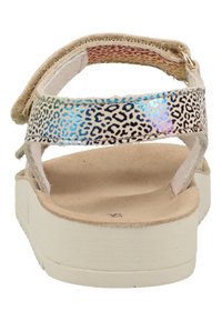 Vista trasera de una sandalia con ante beige y una correa de estampado de leopardo multicolor, que presenta una plantilla texturizada y una suela de goma blanca.
