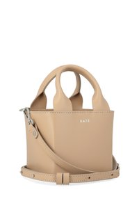 Bolso de mano de cuero beige con asas dobles, diseño estructurado, correa desmontable y marca embellecida. Textura suave con hardware mínimo.