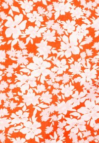 Tessuto di cotone floreale con uno sfondo arancione vivace e motivi di fiori bianchi, che includono diverse forme e dimensioni di fiori.