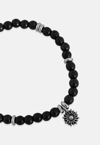 Colar de contas pretas com espaçadores prateados, apresentando um pendente em forma de sol. As contas são redondas e têm uma textura suave.