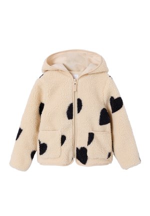 Cremefarbene Fleecejacke mit schwarzen herzförmigen Aufnähern, Frontreißverschluss, Kapuze und zwei Vordertaschen.