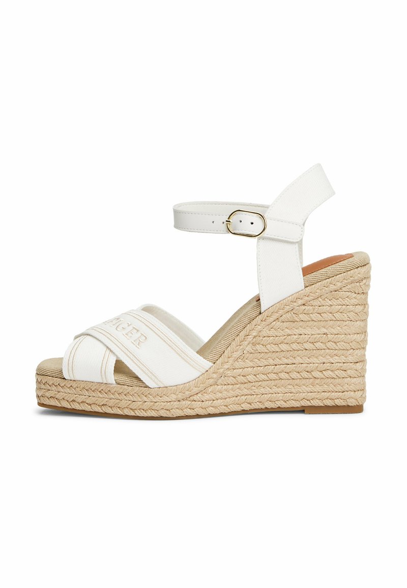 Sandali wedge bianchi con cinturino incrociato in tela e fibbia alla caviglia. Piattaforma espadrille testurizzata con dettagli in juta naturale.