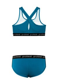 Mėlynas sportinis komplektas, kuriame yra tekstūruota liemenėlė su kryžminiais dirželiais ir nuimamu pagalvėliu, derinama su atitinkamomis šortais ir juodu logotipo juosmeniu.