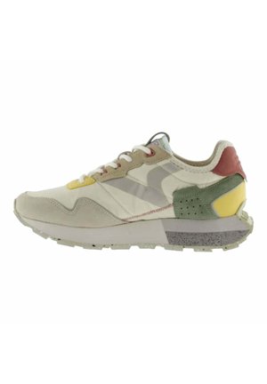 Sneakers beige con una toma superior testurizzata, dotati di accenti gialli, verdi e rossi, una suola intermedia bianca spessa e una suola esterna grigia a motivo.