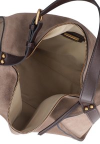 Suède tas in taupe met een lichte beige binnenkant, gouden rits en donkerbruine leren accenten. Open bovenkant zonder zichtbare vakken.