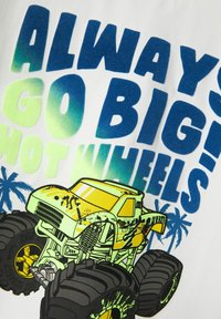 Hvidt stof med fed blå og neongrøn tekst "ALWAYS GO BIG!" samt en illustration af en gul monstertruck med store sorte dæk.