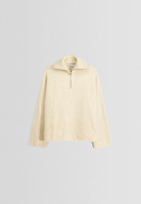 Beiger Pullover mit geripptem Saum und Bündchen. Verfügt über einen halben Reißverschlusskragen und eine weiche Textur. Mit überschnittenen Schultern und lockerer Passform.