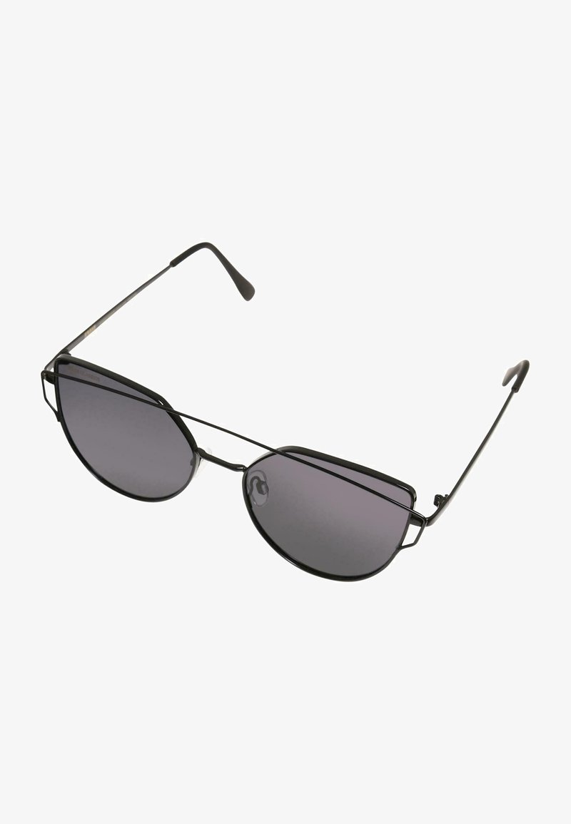 Metāla rāmja saulesbrilles ar tumšiem gradienta objektīviem, leņķa kaķacīm līdzīgā forma, plānas melnas kājas un caurspīdīgas deguna spilventiņi.