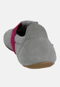 Grauer Wildlederschuh mit einem rosa elastischen Riemen. Runde Spitze und strukturiertem Absatz. Gummisohle mit flachem Design, die Nähte zur Geltung bringt.