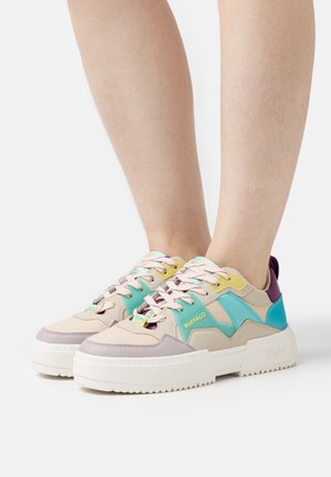 Chunky sneakers with a beige, turquoise, yellow, and purple color scheme. Features textured materials, thick white sole, and distinct lacing.