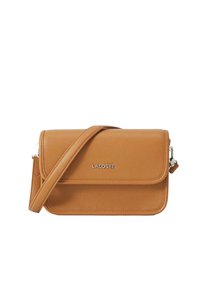 Tan leather crossbody bag with a textured finish, flap closure, adjustable strap, and silver Lacoste logo on the front. Compact and structured design.