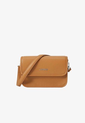 Sac bandoulière en cuir beige avec une finition texturée, fermeture à rabat, bandoulière réglable et logo Lacoste argenté à l'avant. Design compact et structuré.