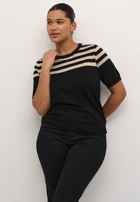 Top en tricot noir à manches courtes avec des rayures beige horizontales sur la poitrine. Le design présente un col rond et une silhouette ajustée.